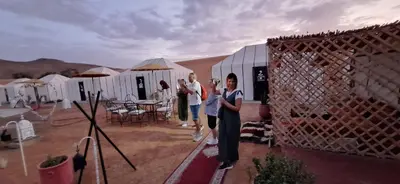 a group of people standing in front of tents at LUXURY Camp in Merzouga