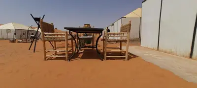 a table and chairs sitting in the desert at LUXURY Camp in Merzouga