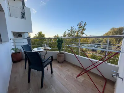a balcony with two chairs and a table on it at Appartement Luxueux, 2 chambres, à 300m de la Gare de train in Fès