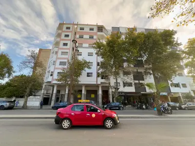 a small red car parked in front of a building at Appartement Luxueux, 2 chambres, à 300m de la Gare de train in Fès