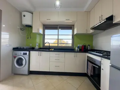 a kitchen with a washing machine and a window at Appartement Luxueux, 2 chambres, à 300m de la Gare de train in Fès