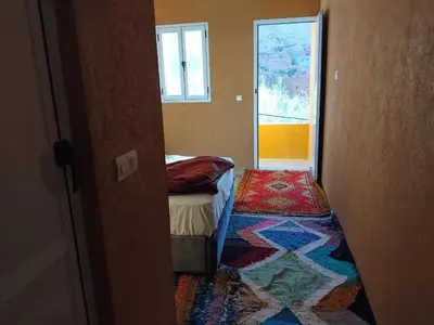 a small room with a bed and a window at Pergolas Tamakouchte in Ouarzazate