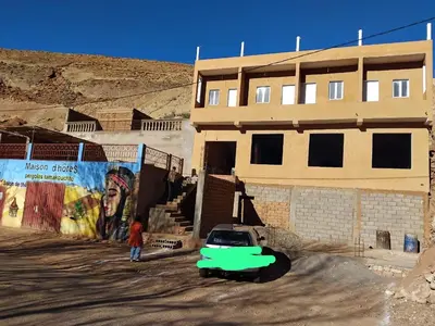 a green car parked in front of a building at Pergolas Tamakouchte in Ouarzazate