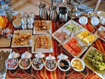 a table with many plates of food on it at Luxury Desert Camp Merzouga in Merzouga