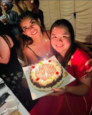 two women holding a cake in a box at Luxury Desert Camp Merzouga in Merzouga