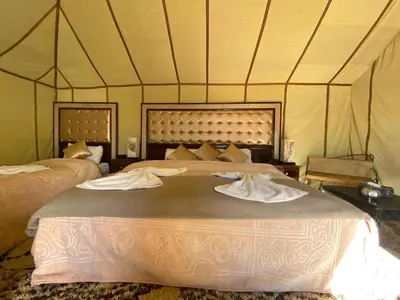 a bedroom with two beds in a tent at Luxury Desert Camp Merzouga in Merzouga