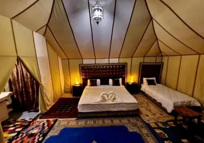 a bedroom with two beds in a tent at Luxury Desert Camp Merzouga in Merzouga
