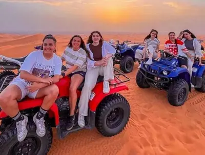 a group of women sitting on atvs in the desert at Glamping luxury camp in Merzouga