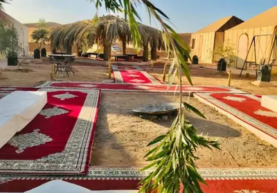 a row of red carpets on the ground in a courtyard at Glamping luxury camp in Merzouga