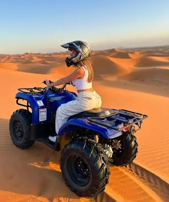 a woman riding a quad bike in the desert at Glamping luxury camp in Merzouga