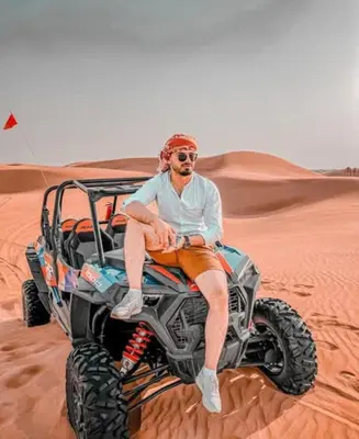 a man sitting on a wheeler in the desert at Glamping luxury camp in Merzouga