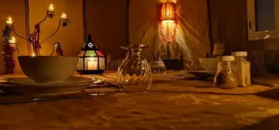 a table with a glass bottle on top of it at Chez Sadoq Luxury Camp in Merzouga