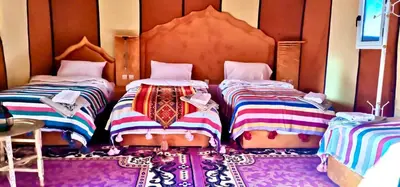 two beds sitting next to each other in a room at Chez Sadoq Luxury Camp in Merzouga