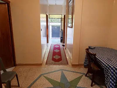 a hallway with a table and a rug on the floor at Rez-de-chaussée villa touta in Beni Mellal