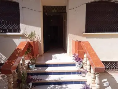 a building with stairs and a door with potted plants at Rez-de-chaussée villa touta in Beni Mellal