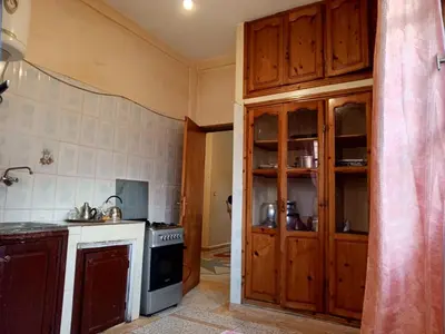 a kitchen with wooden cabinets and a stove top oven at Rez-de-chaussée villa touta in Beni Mellal