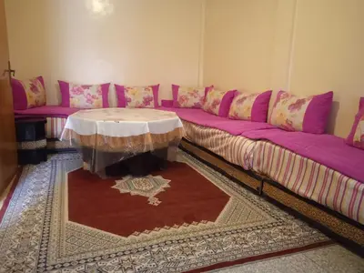 a living room with a purple couch and a table at Rez-de-chaussée villa touta in Beni Mellal
