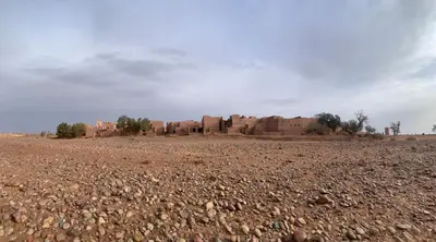 a desert with rocks and buildings in the background at Dar Nuyum in Bou Nou