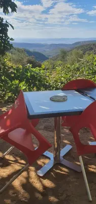 a picnic table with two red chairs and a view at Gîte tazekka in Taza