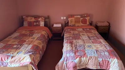 two twin beds in a room with tworams at Riad Bouchahoud Hotel in Telouet in Telouet