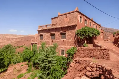 an old brick building on the side of a mountain at Riad Bouchahoud Hotel in Telouet in Telouet