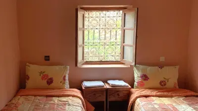 a room with two beds and a window at Riad Bouchahoud Hotel in Telouet in Telouet