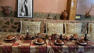 a table with bowls and plates on it with a table cloth at Riad Bouchahoud Hotel in Telouet in Telouet