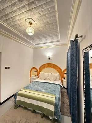 a bedroom with a bed with a blue comforter at RIAD dreams dades in Tamellalt