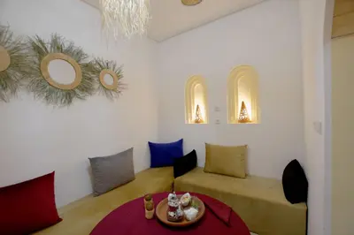 a living room with a red table and chairs at RIAD dreams dades in Tamellalt