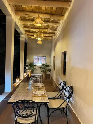 a dining room with a table and chairs and a chandelier at RIAD dreams dades in Tamellalt