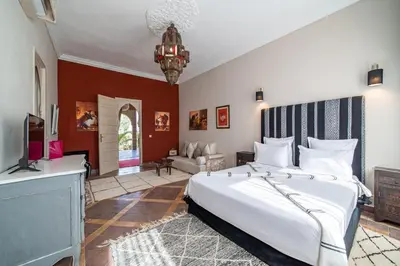 a bedroom with a large bed and a tv at Villa Chems - Al Ouidane in Marrakech