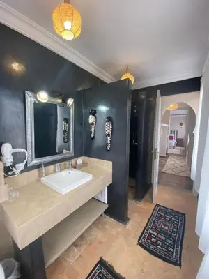 a bathroom with a sink and a mirror and a hallway at Villa Chems - Al Ouidane in Marrakech