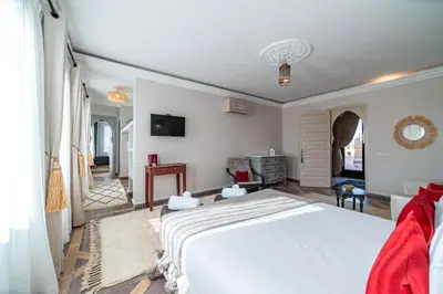 a bedroom with a large white bed and a living room at Villa Chems - Al Ouidane in Marrakech