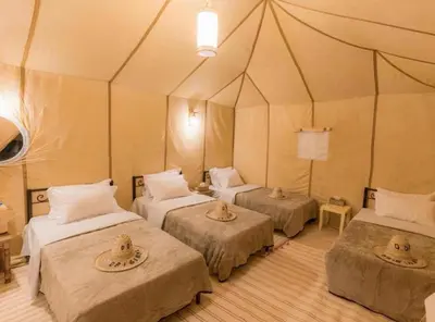 a room with three beds in a tent at Super Luxury camp in Merzouga