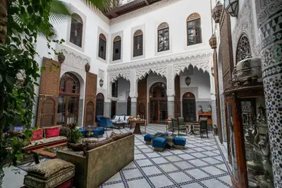 a courtyard of a building with chairs and tables at Riad Semlalia in Fès