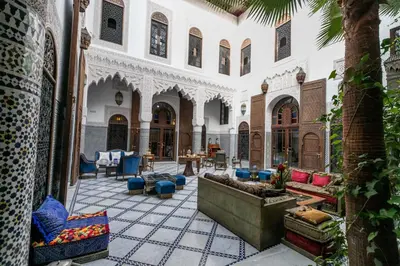 a courtyard with chairs and tables in a building at Riad Semlalia in Fès
