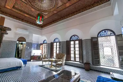 a bedroom with a bed and a room with windows at Riad Semlalia in Fès