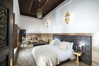 a bedroom with a large bed and a living room at Riad Semlalia in Fès