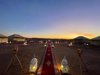 a group of lights on a road at sunset at Sahara Dunes Camp in Merzouga