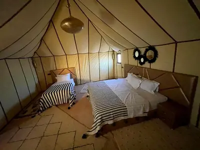 a room with a bed in a tent at Sahara Dunes Camp in Merzouga