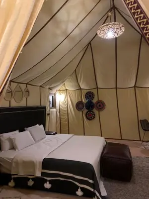 a bedroom with a bed in a tent at Sahara Dunes Camp in Merzouga