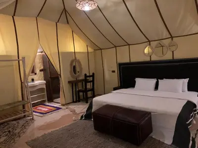 a bedroom with a bed in a tent at Sahara Dunes Camp in Merzouga