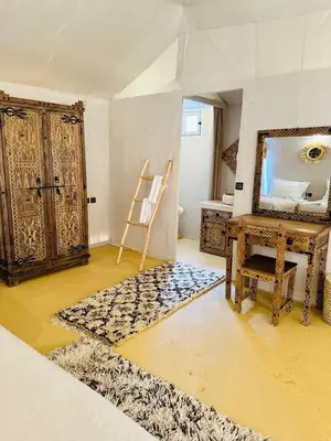 a room with a mirror and a desk and a table at Merzouga Top Luxury Camp in Merzouga