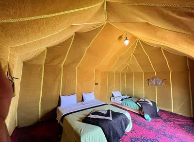 a bedroom with a bed in a tent at Luxury Camp Rachid in Merzouga