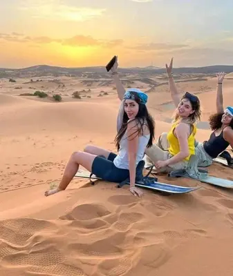 a group of women sitting in the desert at Luxury Camp Rachid in Merzouga