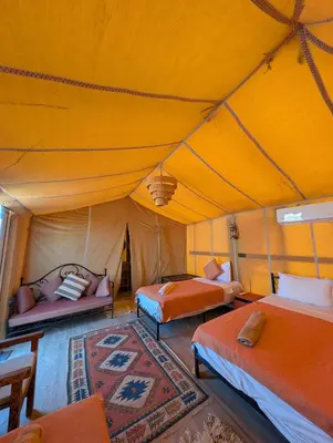 a tent bedroom with two beds and a rug at Luxury Desert Camp Merzouga with Air Conditioning and Heating in Merdani