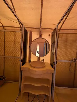a bathroom with a sink and a mirror at Luxury Desert Camp Merzouga with Air Conditioning and Heating in Merdani