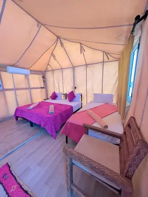 a room with two beds in a tent at Luxury Desert Camp Merzouga with Air Conditioning and Heating in Merdani