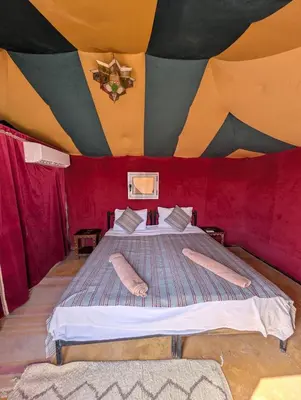 a bedroom with a bed in a tent at Luxury Desert Camp Merzouga with Air Conditioning and Heating in Merdani
