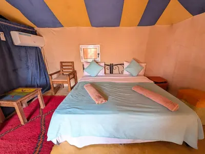 a bedroom with a bed in a tent at Luxury Desert Camp Merzouga with Air Conditioning and Heating in Merdani